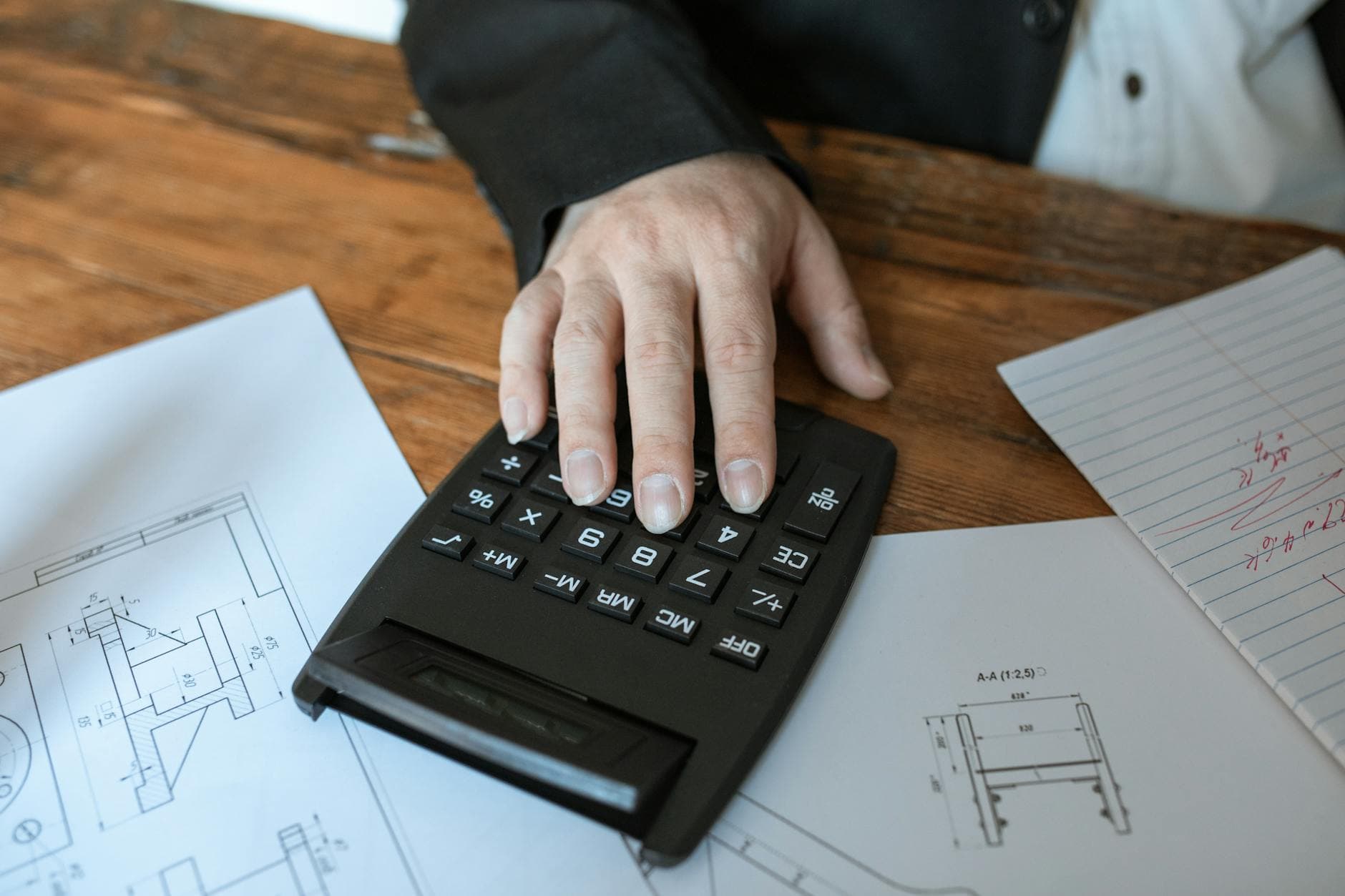Construction subcontractor reviewing CIS deduction statement on a tablet at a building site in Manchester