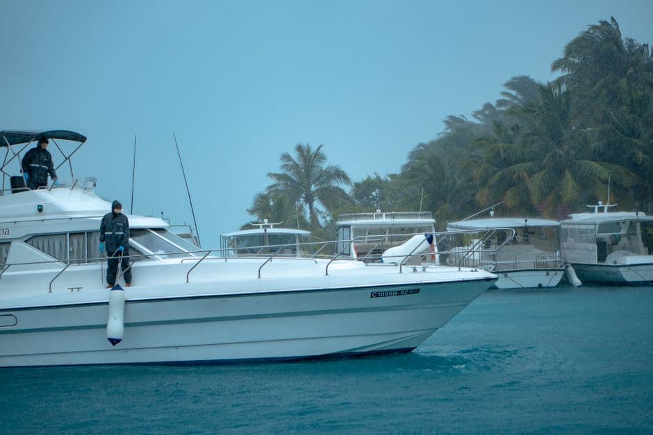 Deck of a large motor yacht at a marina berth with mooring lines coiled on the teak