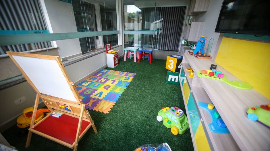 Wooden building blocks and toys arranged on a low table in a bright nursery playroom