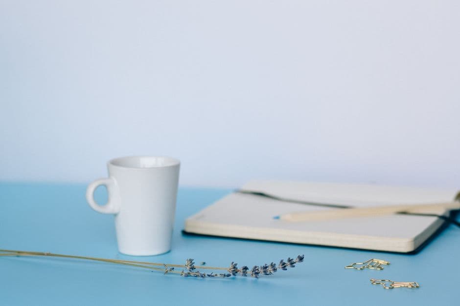 A wall calendar and a small stack of paper receipts on a plain desk
