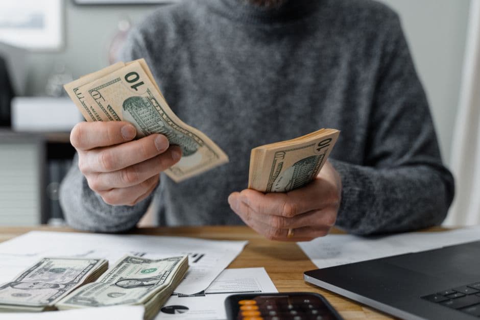 Small business owner reviewing a cash flow forecast spreadsheet at a desk with a calculator and bank statements