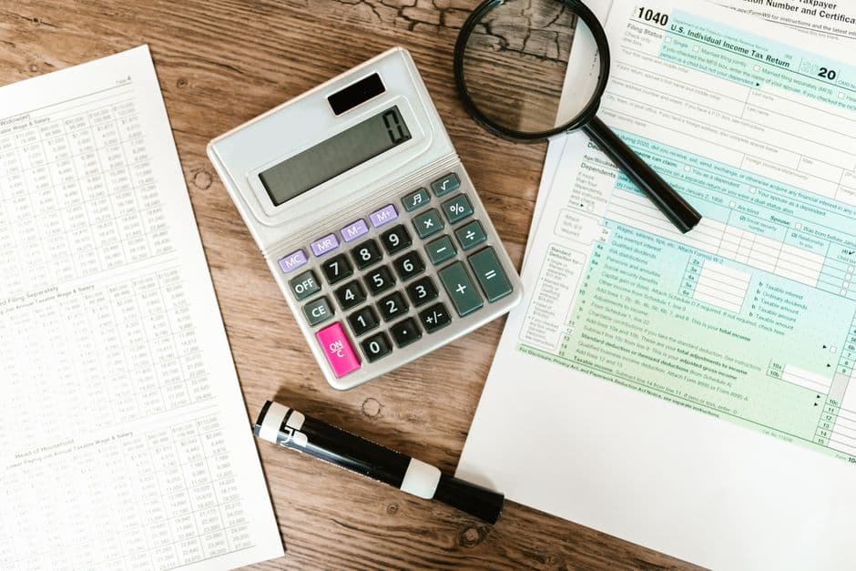 UK business owner completing a VAT return on a laptop with accounting records and a calculator on the desk