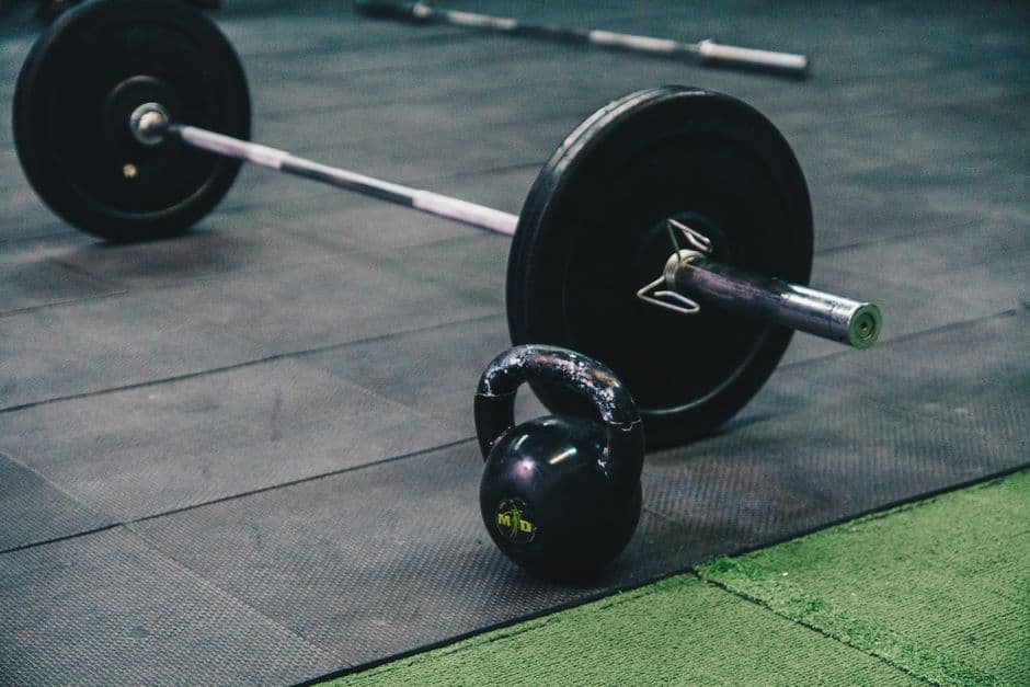 Row of exercise bikes and free weights in an empty commercial gym