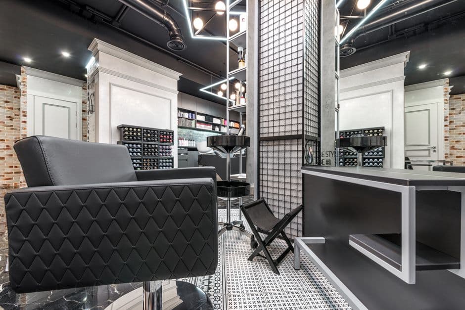 Empty styling chairs and mirrors along the wall of a modern hair salon