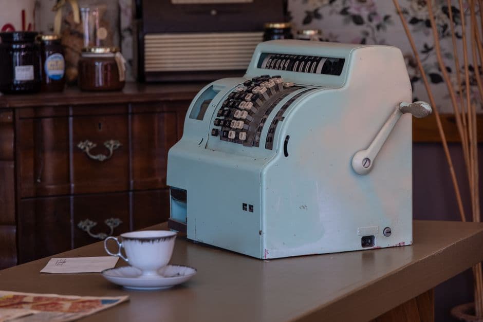 Till receipt roll and card terminal on the counter of a small mixed-goods shop