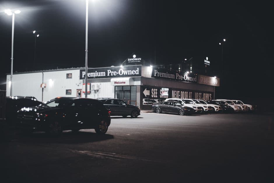 Row of used cars on a forecourt with windscreen price cards