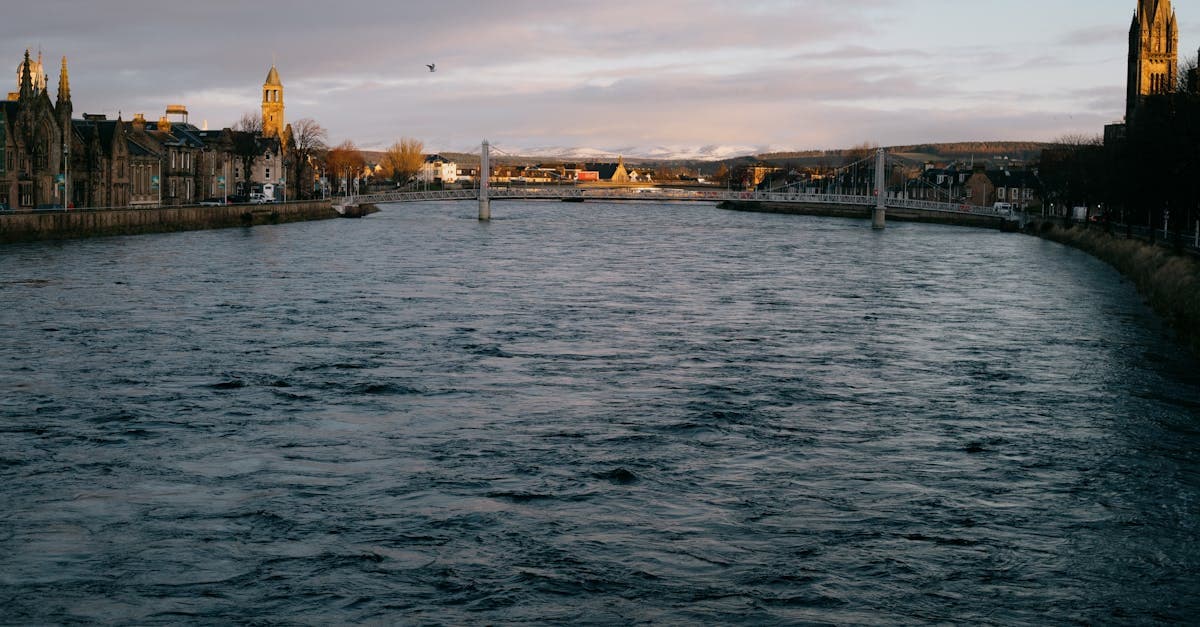 A picturesque view of River Ness with Inverness cityscape at dawn, showcasing historical architecture.
