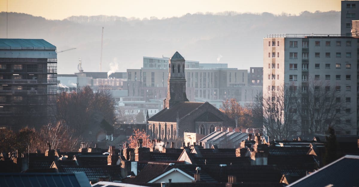 Urban view of Bristol featuring St Luke's Church amidst city buildings during a serene sunset.