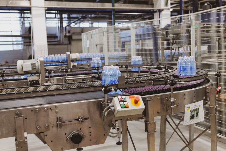Trays of bread and cakes coming out of a commercial oven in a small food production bakery