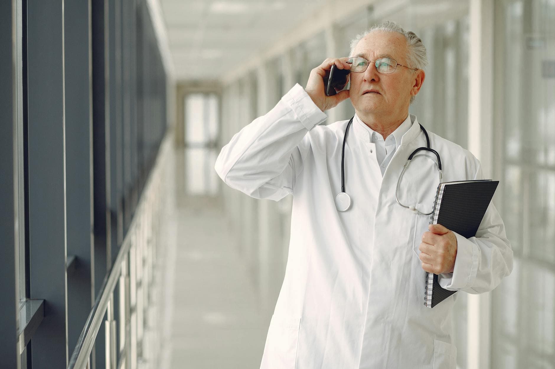 A doctor in a white coat reviewing financial documents with an ICAEW qualified accountant in a modern UK office setting
