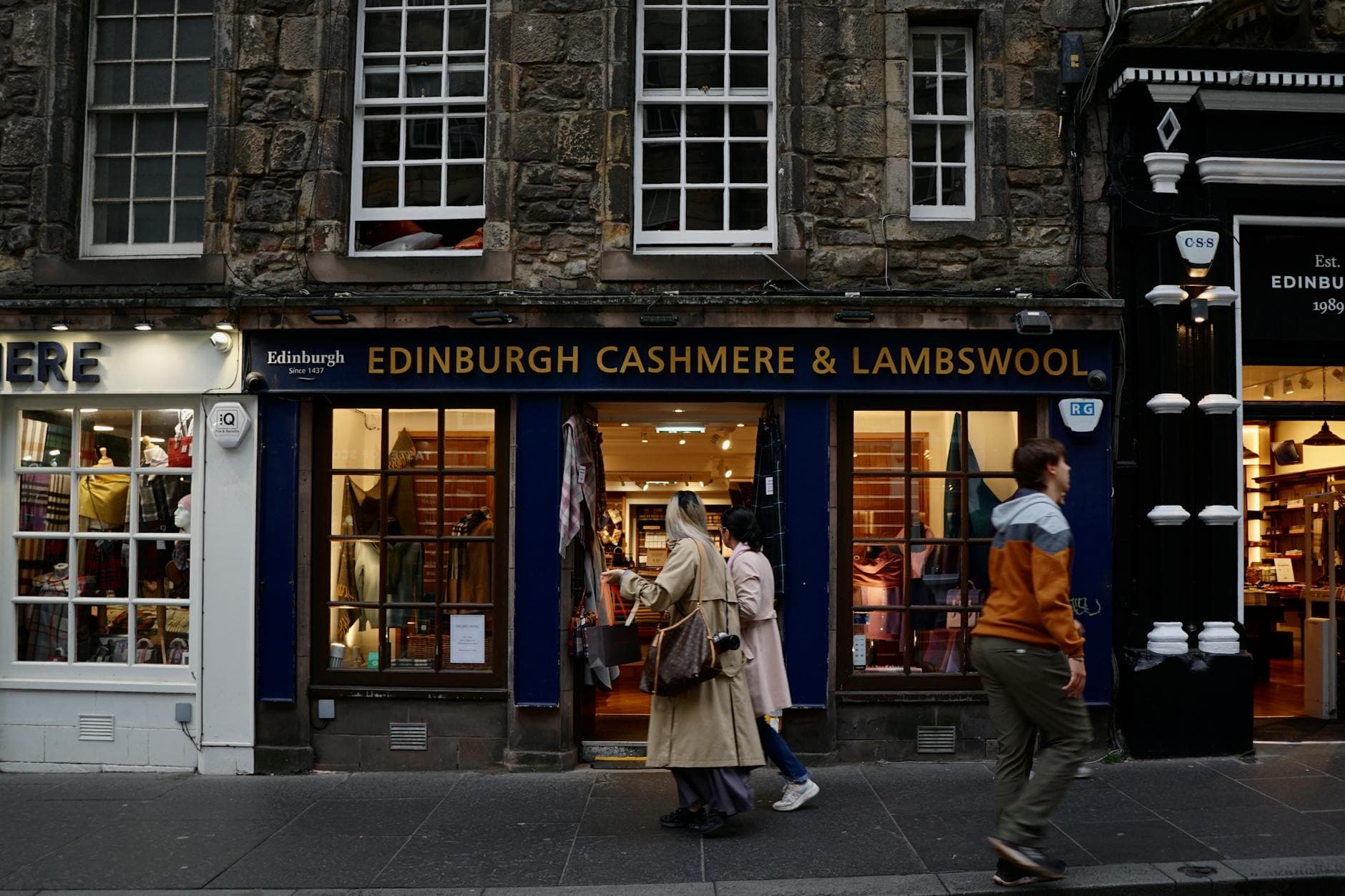 Two people looking at a tablet in a modern UK retail shop with shelves of products