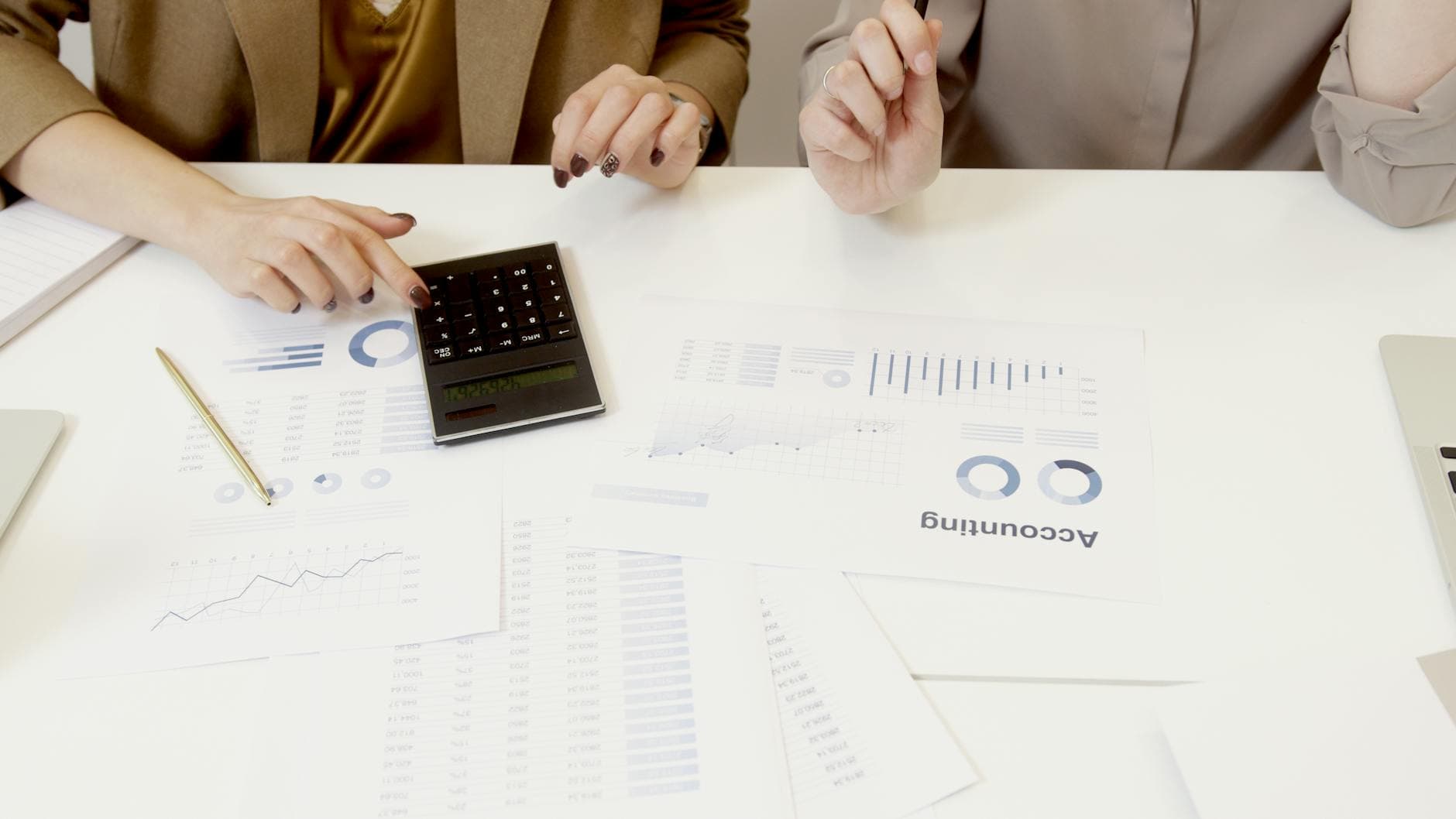 Software development team working in a modern Manchester office with a financial report on a tablet