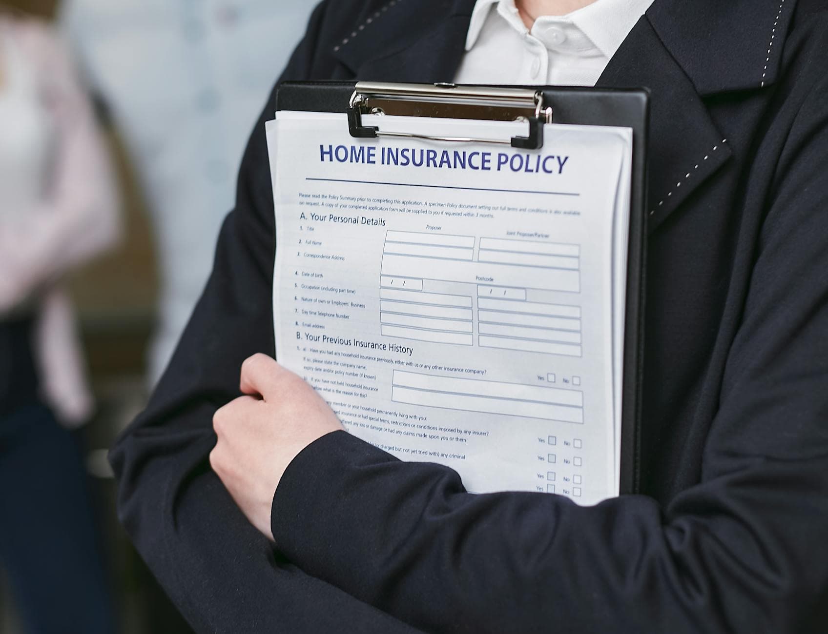 UK business owner working from a home office with a laptop and paperwork, calculating home insurance tax deductions