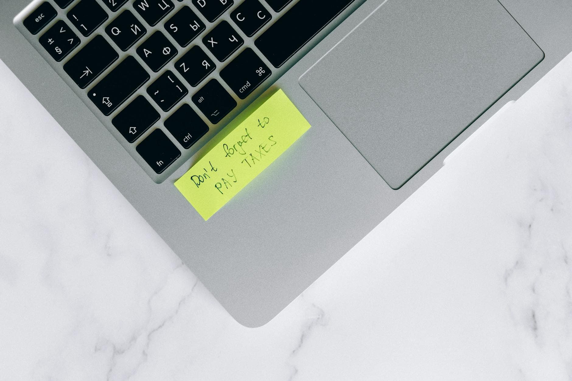 UK business owner reviewing director pay strategy on laptop with calculator and payslip, London office setting