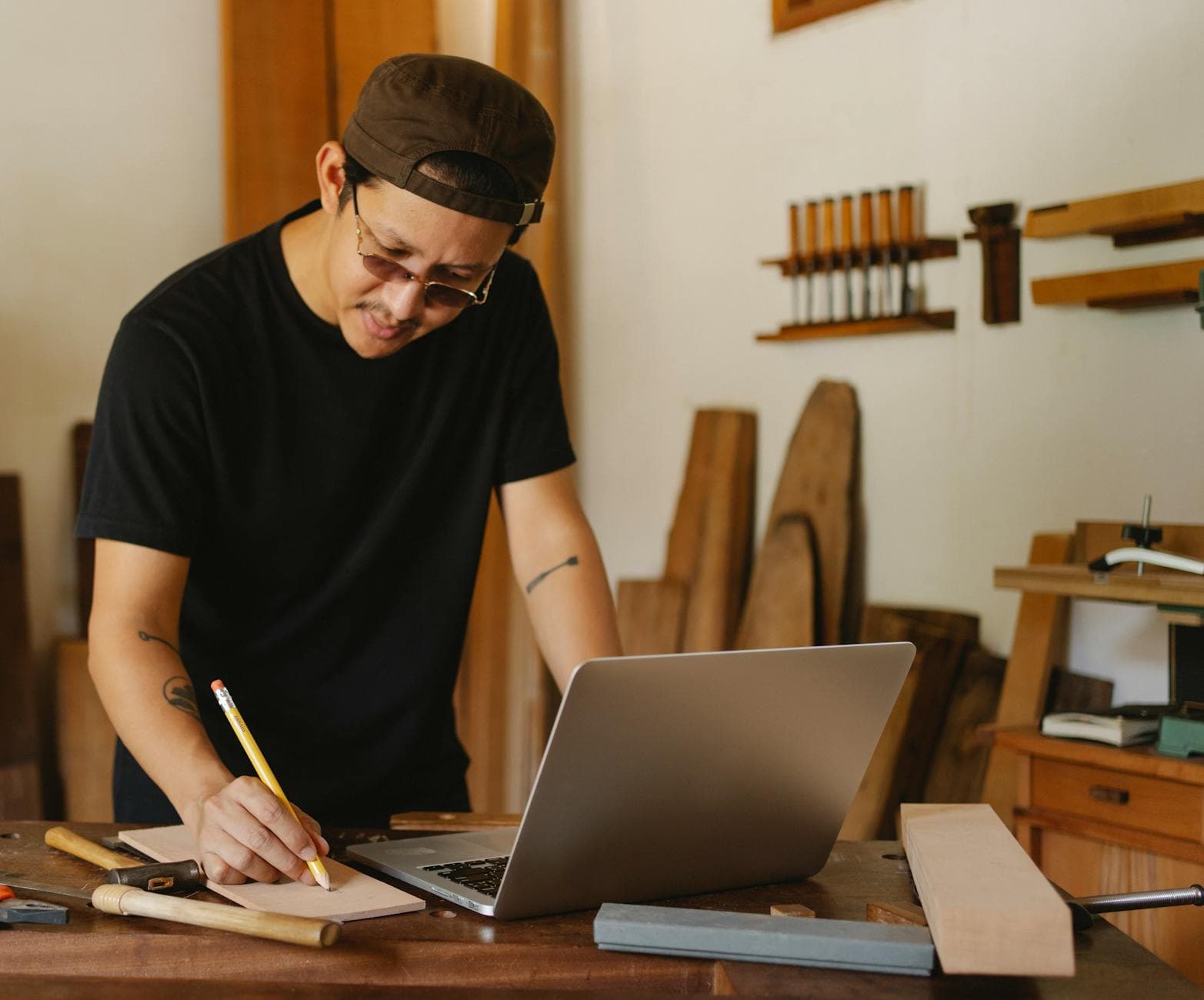 Sole trader working on a laptop in a home office in Manchester, UK, with a notebook and calculator