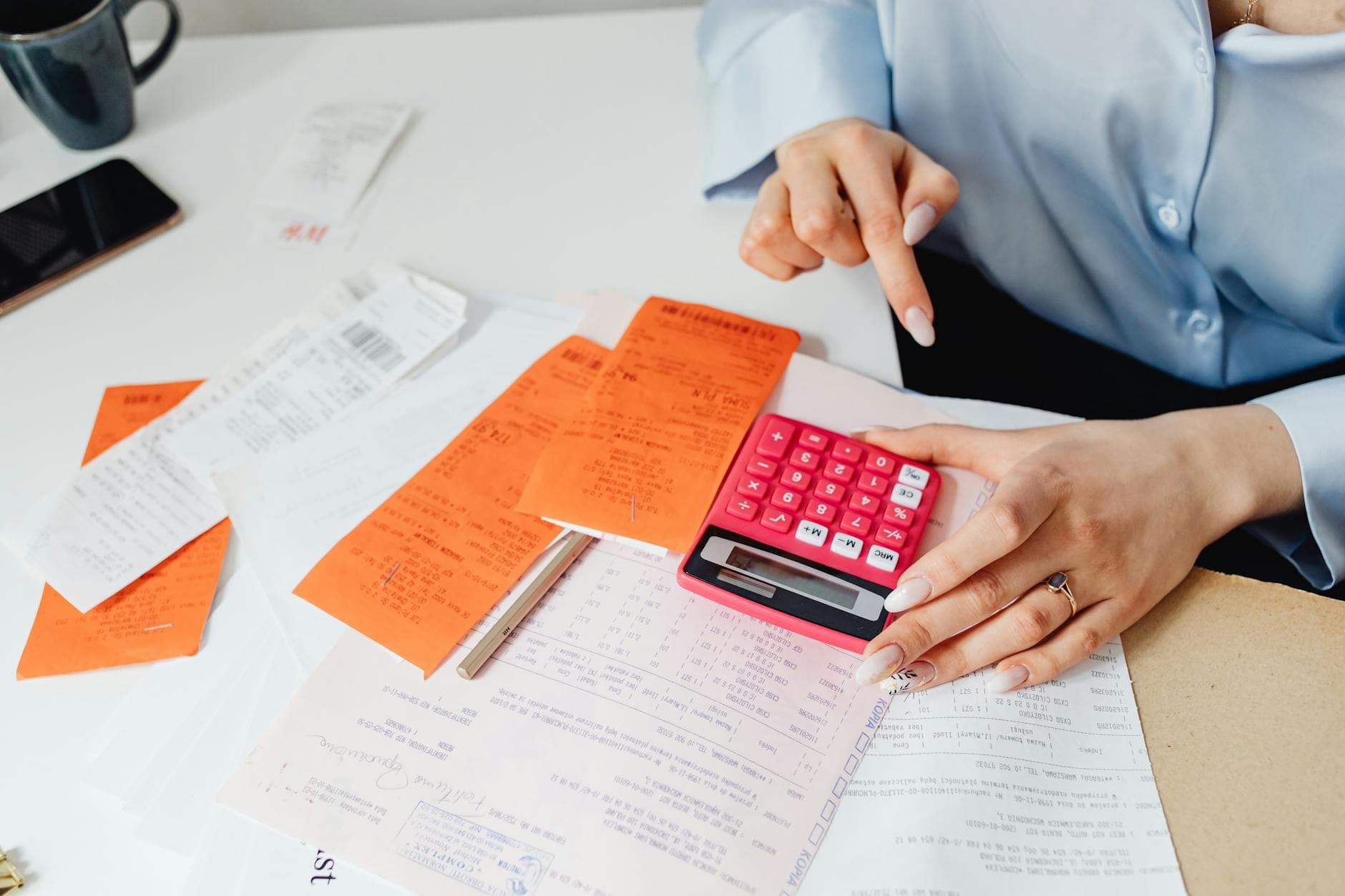 UK accountant reviewing limited company accounts on a laptop in a modern office with a calculator and coffee on the desk