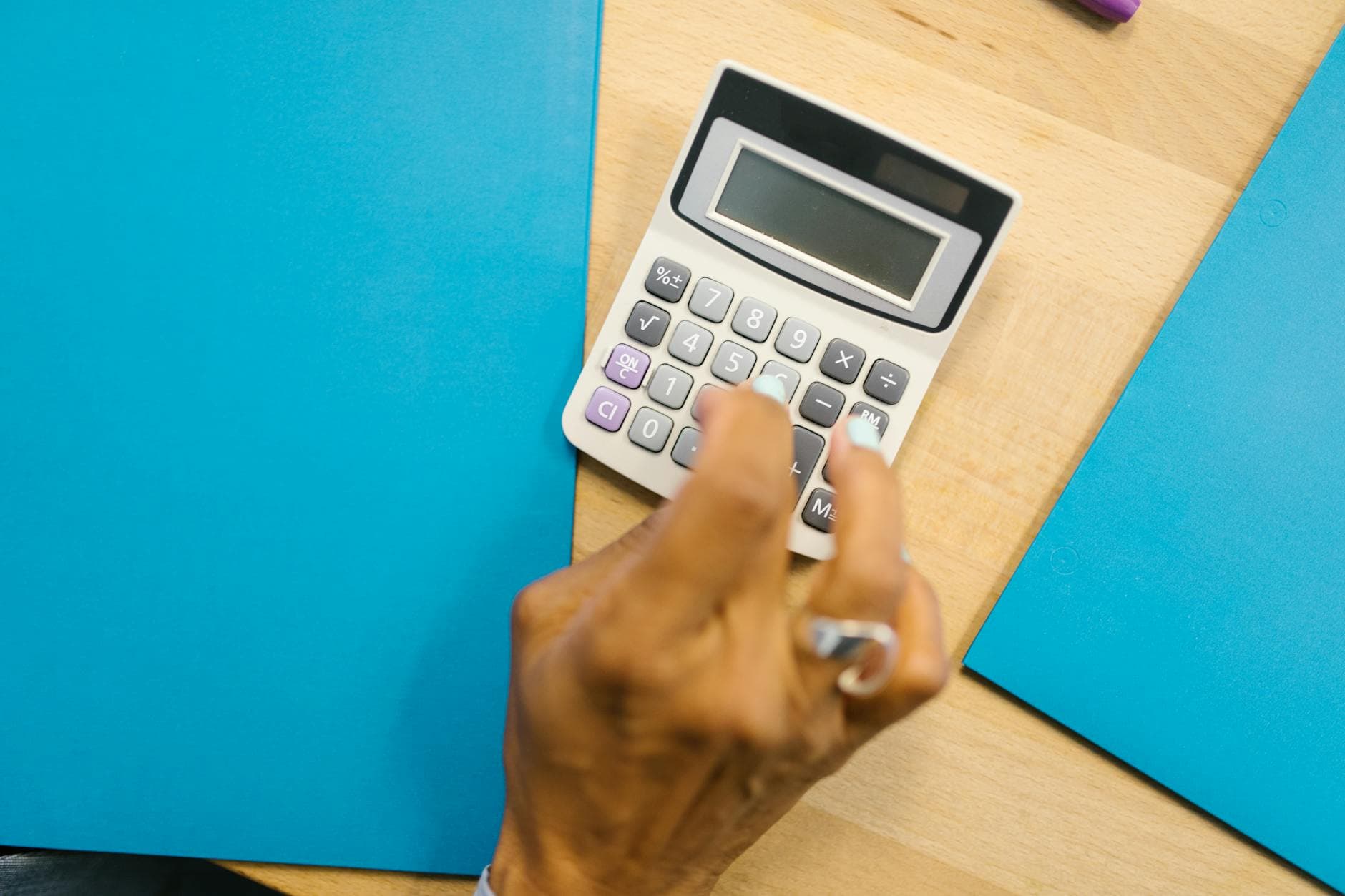 Professional accountant meeting with a small business owner in a modern UK office, discussing financial documents and a laptop screen showing accounting software.