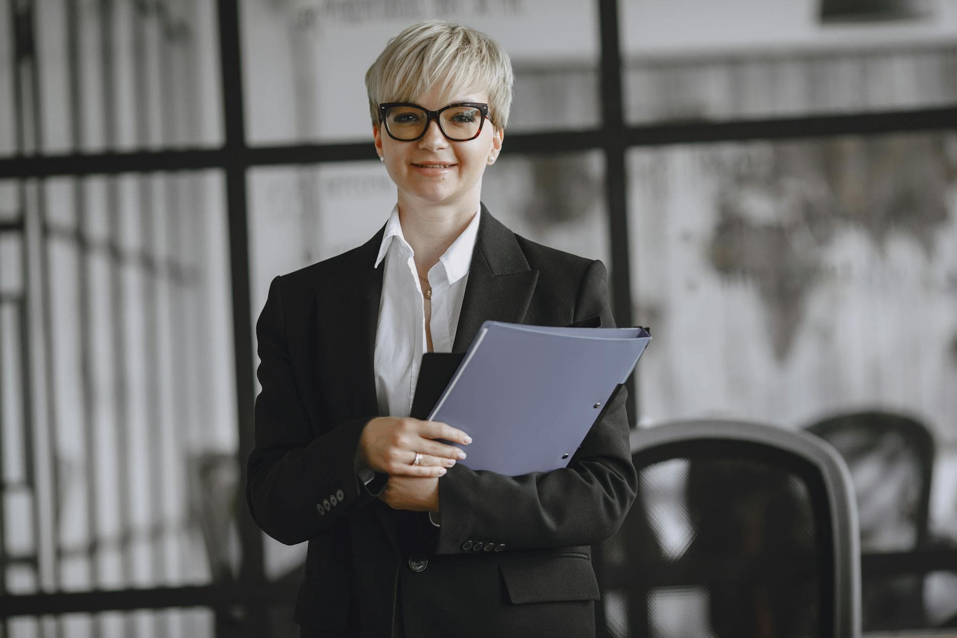 UK accountant reviewing payroll documents for a limited company director in a modern office in Manchester