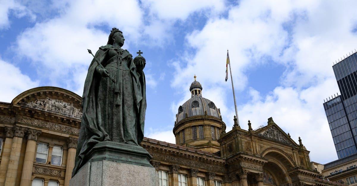 Statue of Queen Victoria outside Birmingham Council House with blue sky background.