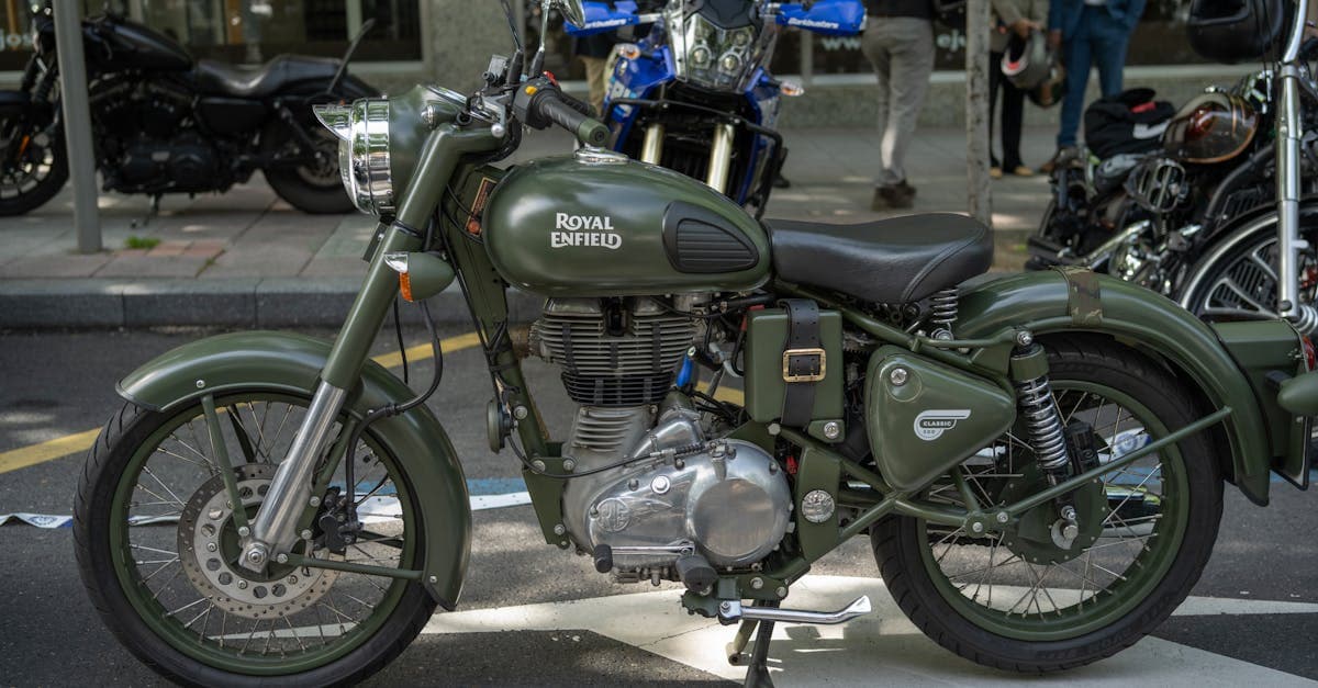 Vintage green Royal Enfield Classic parked outdoors on a city street.