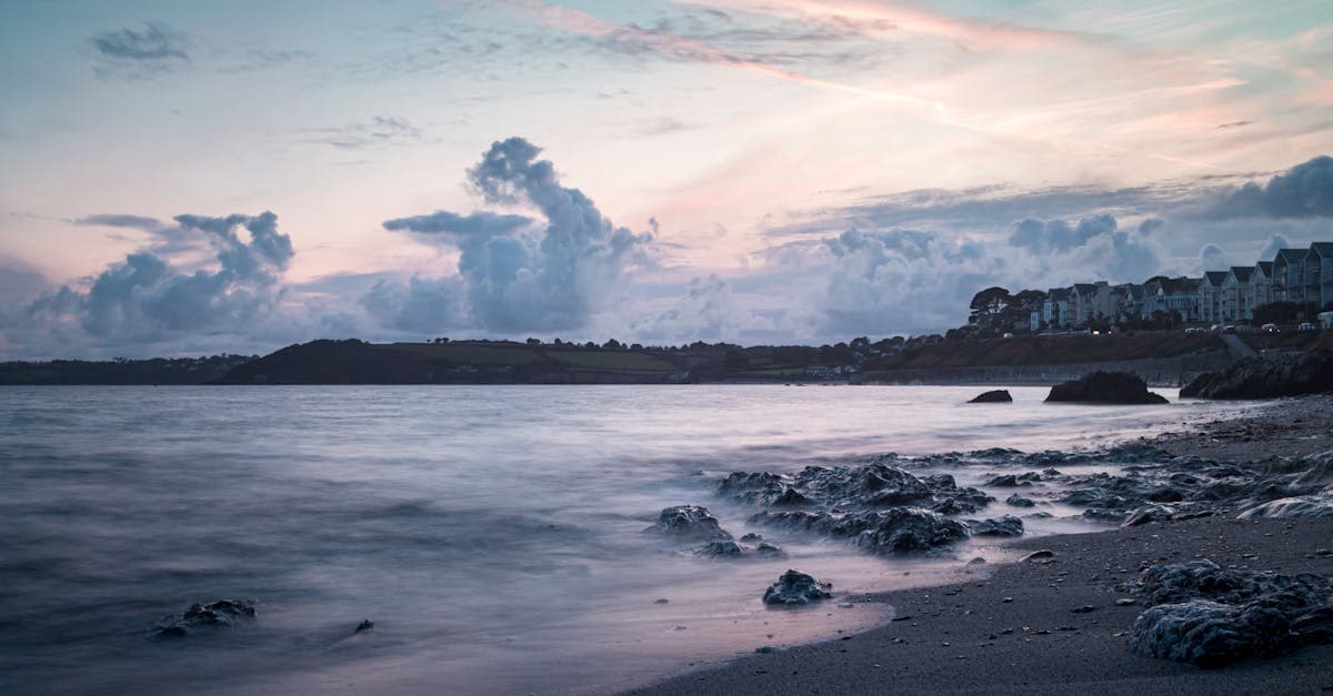 Breathtaking sunset view of Falmouth's rocky beach and tranquil sea, offering a peaceful escape.