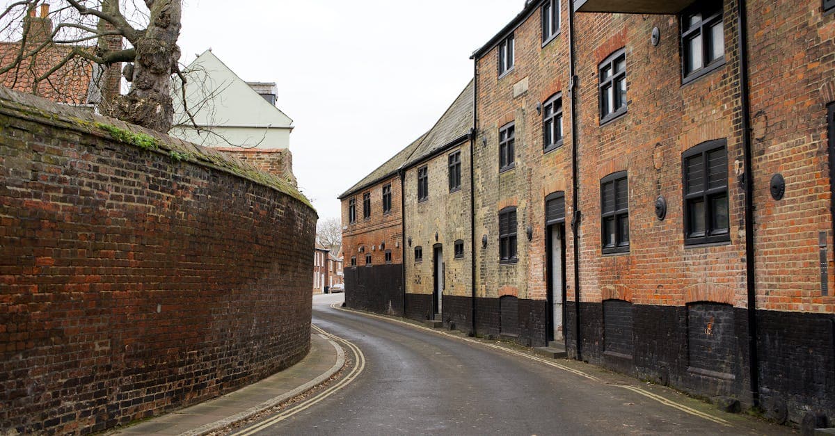 Quiet urban street in King's Lynn with historic brick buildings and curved walls.