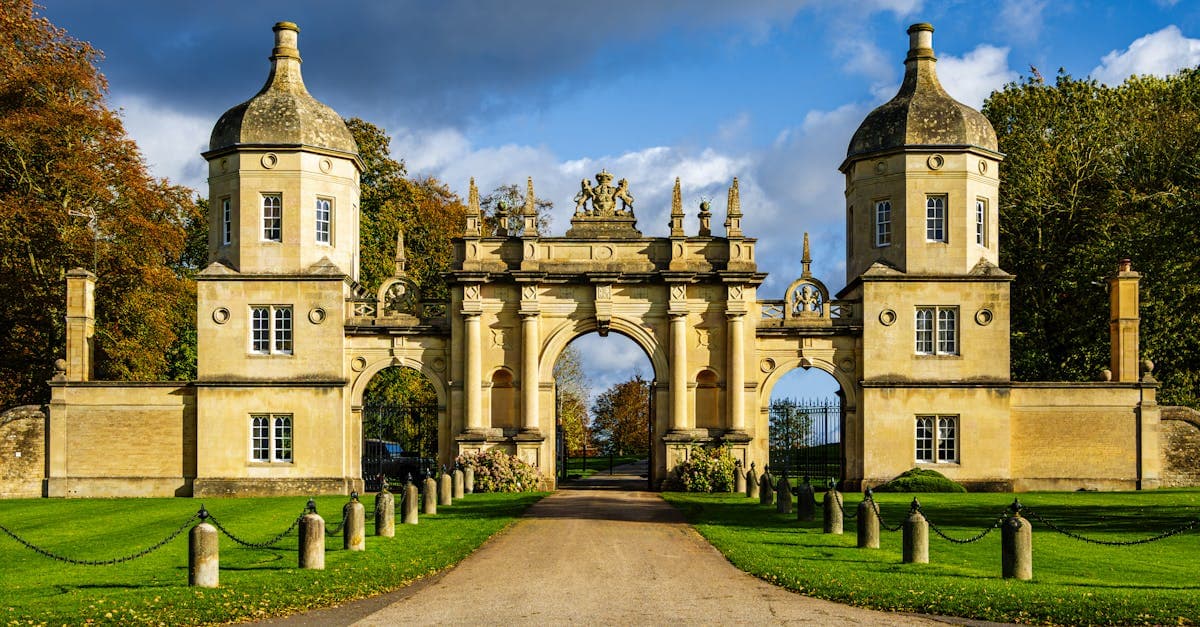 Grand entrance gate in Peterborough surrounded by lush greenery.