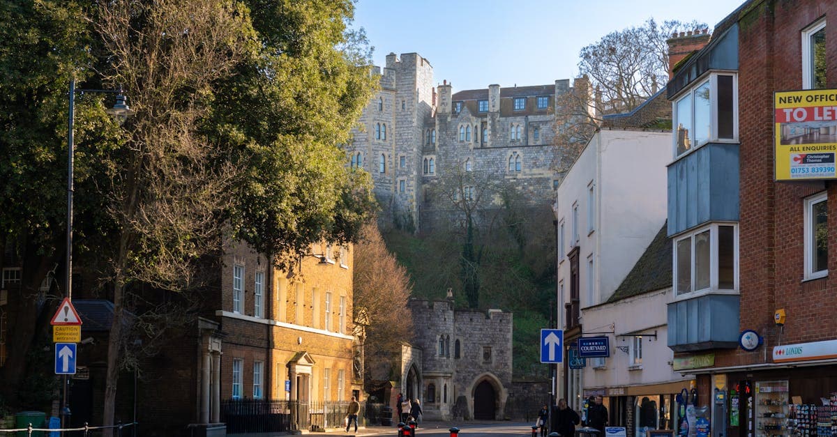 Charming street view of Windsor with Windsor Castle towering in the background on a sunny day.