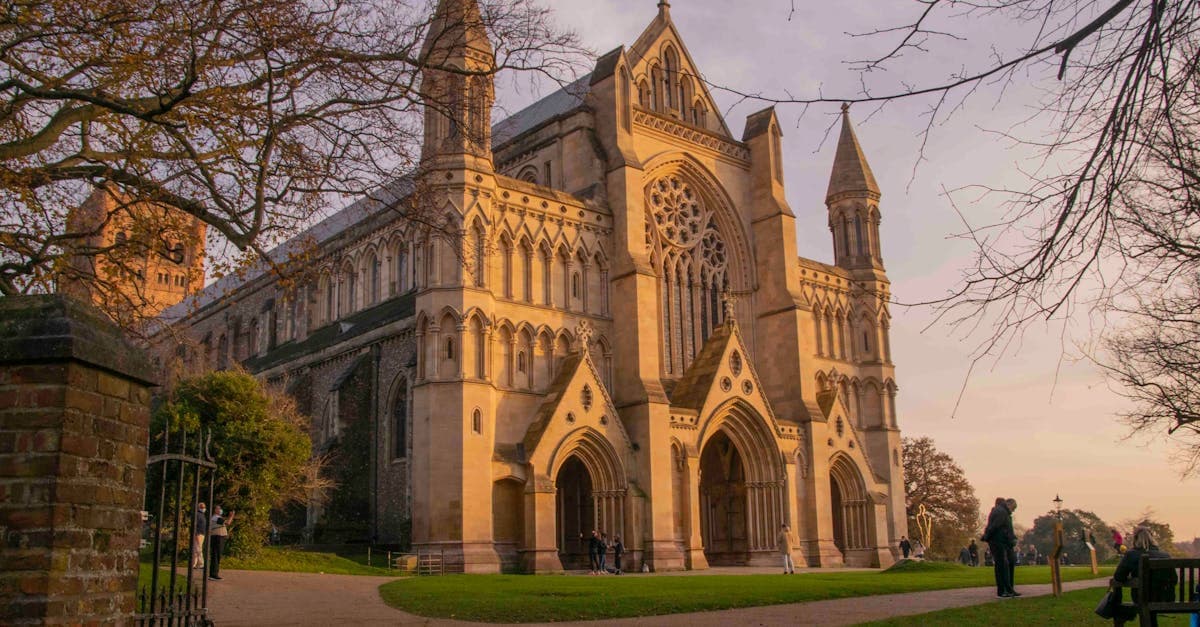 The historic St Albans Cathedral lit by the warm glow of a sunset in England.