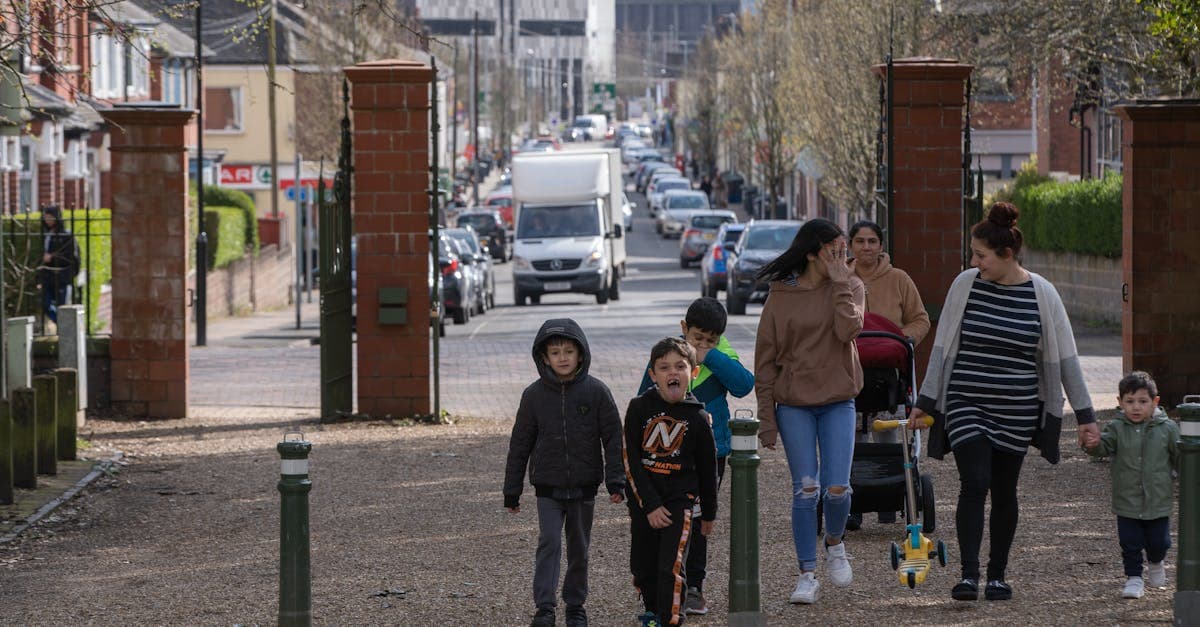 A group of families enjoying a walk on a bustling street in England. Captured during a lively spring day.