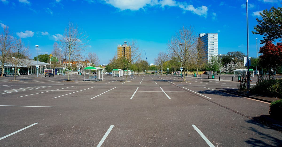 A deserted parking lot under a vivid blue sky in England, showcasing urban isolation.