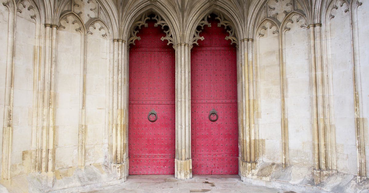 Explore the gothic architecture of Winchester Cathedral's red doors and detailed arches in England.