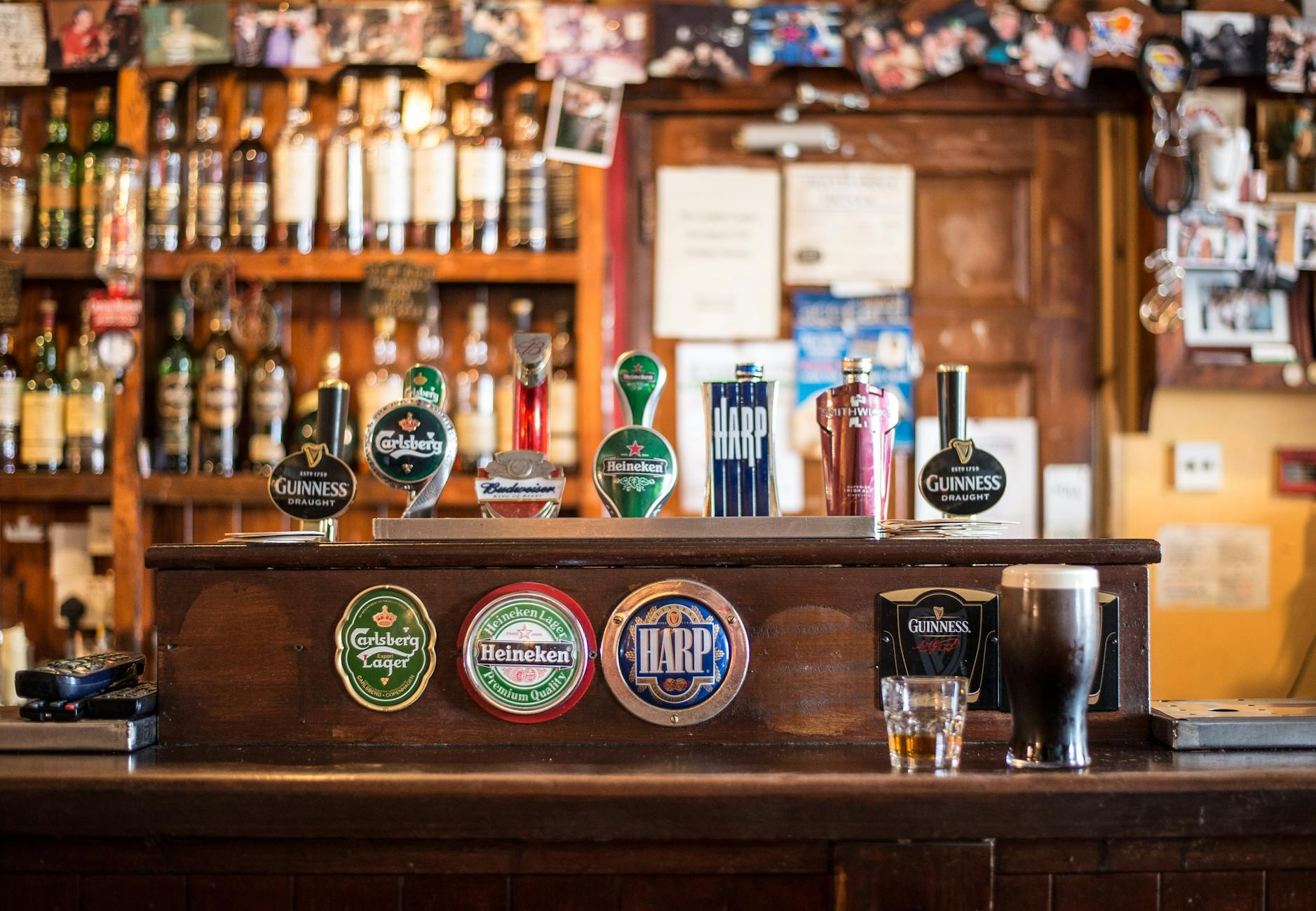A modern pub interior in Manchester's Northern Quarter with bar staff serving drinks, representing a UK hospitality business