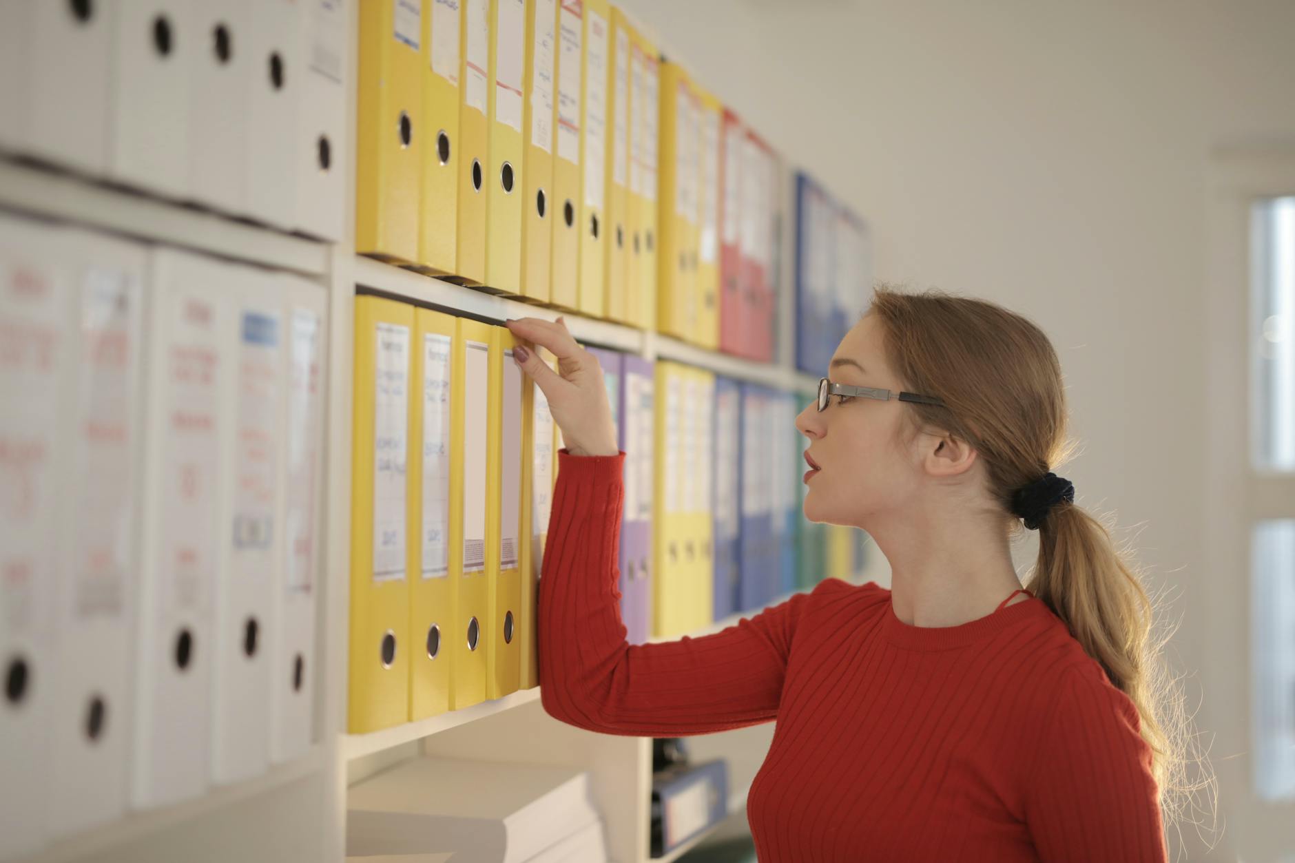 Limited company director reviewing paper and digital bookkeeping records for HMRC 6 year retention period in a UK office