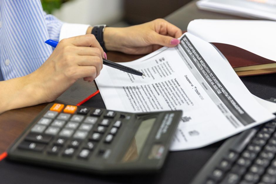 Accountancy practice owner reviewing a client fee ledger before a practice sale