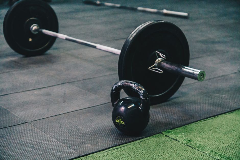 Row of exercise bikes and free weights in an empty commercial gym