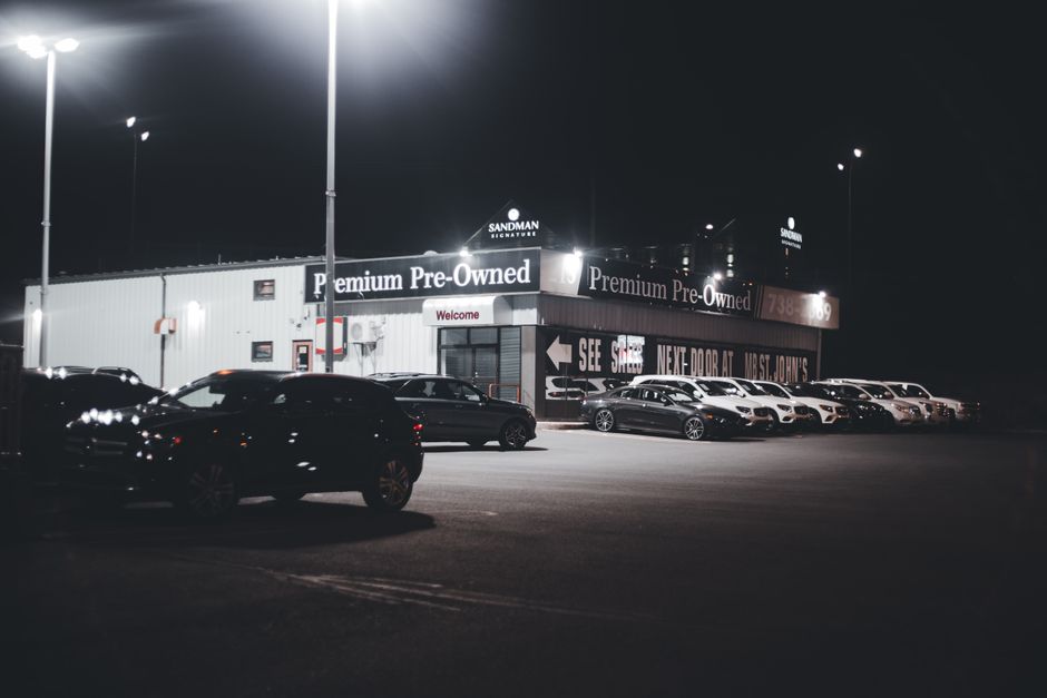 Row of used cars on a forecourt with windscreen price cards